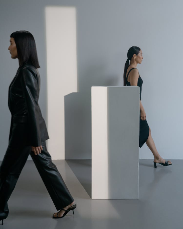 Women In Black Clothes Walking Near A Plinth