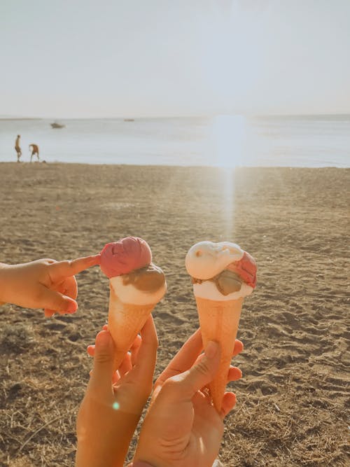 Free Couple with ice cream cones on sandy beach Stock Photo