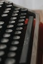 Closeup of obsolete retro typewriter with white letters on black buttons for publishing document