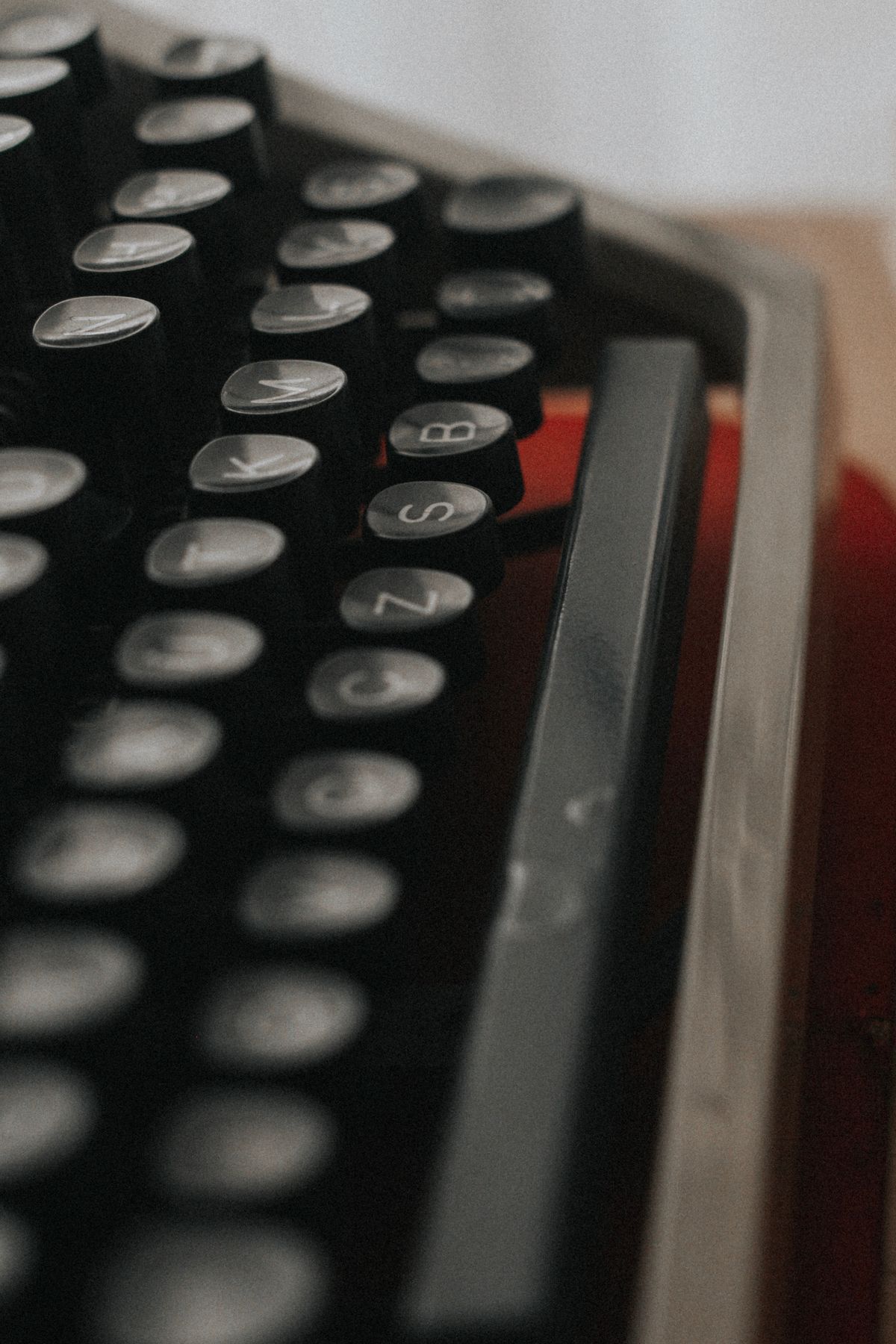 Fileiras de letras em uma máquina de escrever antiga, em close, remetendo a tipografia de época