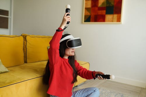 A Woman in Red Sweater and Blue Denim Jeans Wearing White and Black Vr Headset
