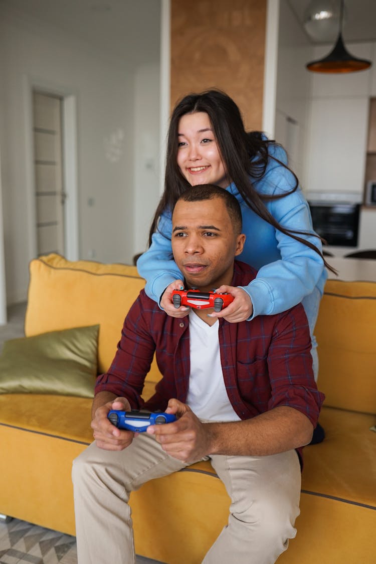 Woman And Man Holding Gaming Remote Controllers