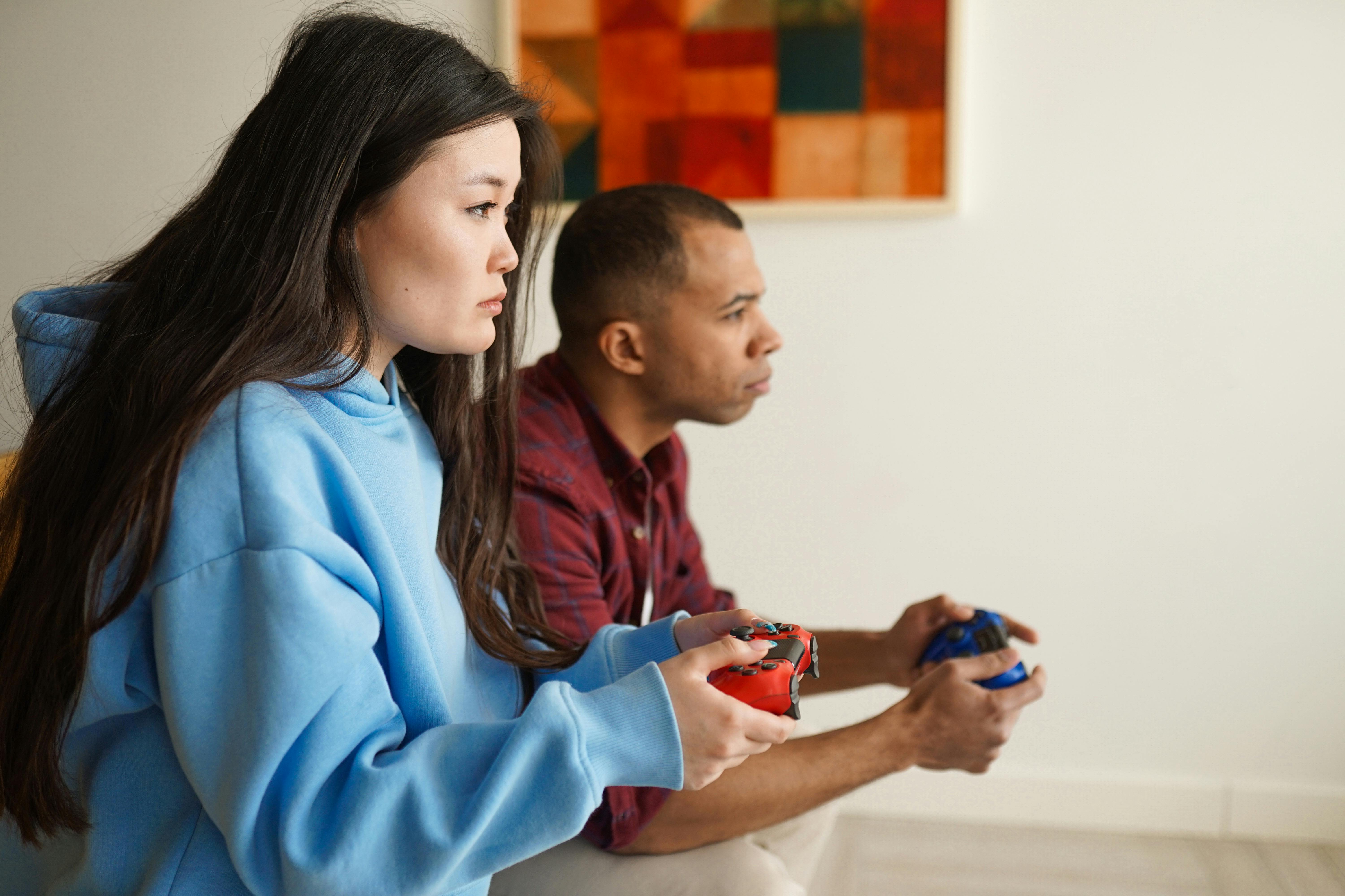 Cheerful boyfriend and girlfriend playing video games to win. Happy couple  using controller to play online game and winning gameplay on console.  People holding joystick to have fun Stock Photo - Alamy