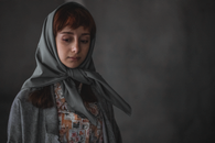 Portrait of a woman with a headscarf, exuding a contemplative mood.