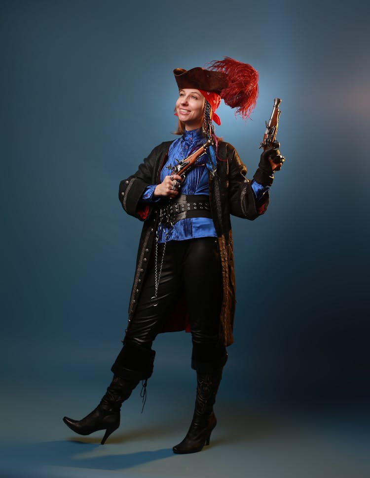 A Woman In Pirate Costume Holding A Gun