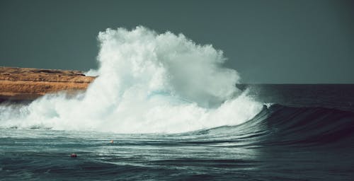 Waves Crashing on Brown Rock Formation