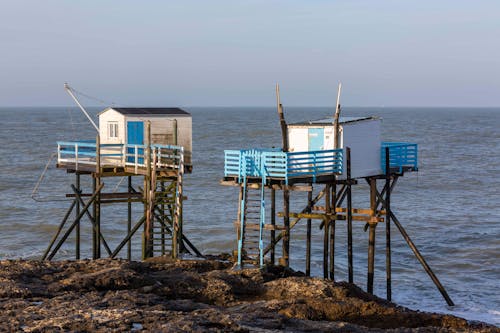 Foto d'estoc gratuïta de aigua, cabana de pesca, capvespre