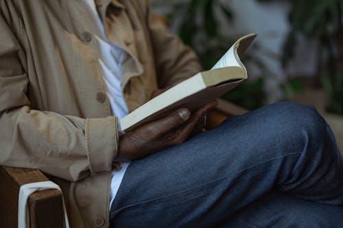 Person in Blue Denim Jeans and Brown Coat