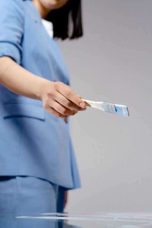 Free Close-up of a woman holding a paintbrush, focusing on creativity and art in a studio. Stock Photo