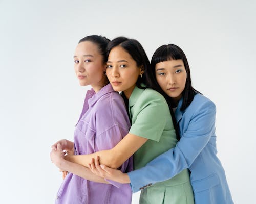 Young Women in Trendy Pastel Outfits Holding each other Close
