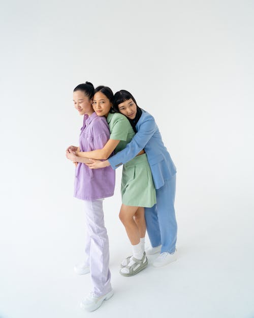 Young Women in Trendy Pastel Outfits Holding each other Close