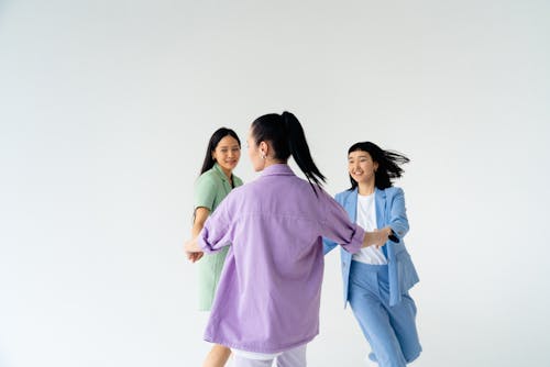 Young Women in Trendy Pastel Outfits Holding Hands