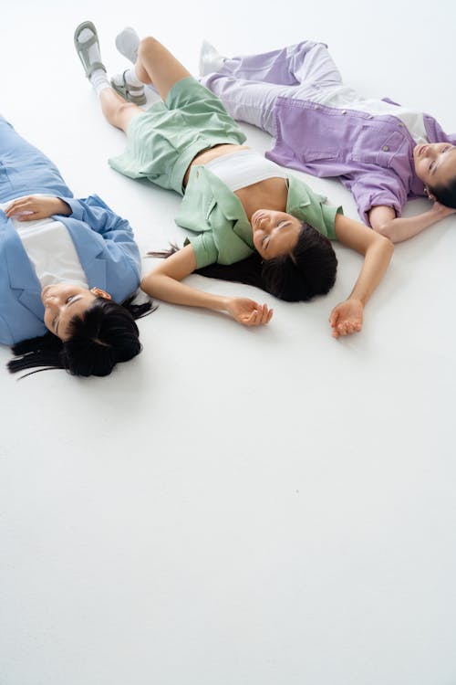 Fashionable Women Lying on White Floor
