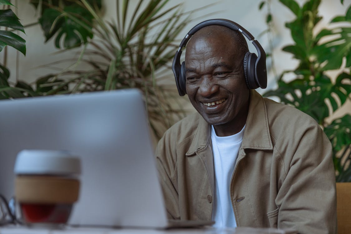 Photo of an Old Man Looking at the Laptop