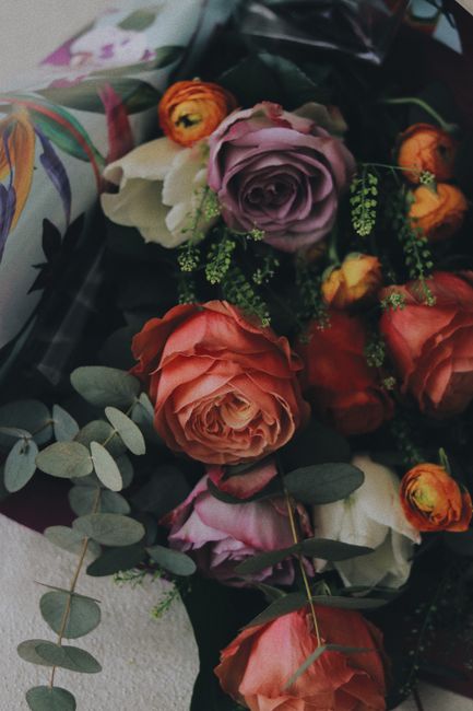Blossoming floral bouquet of roses with tender petals and Eucalyptus sprigs with pleasant aroma in ornamental wrapper