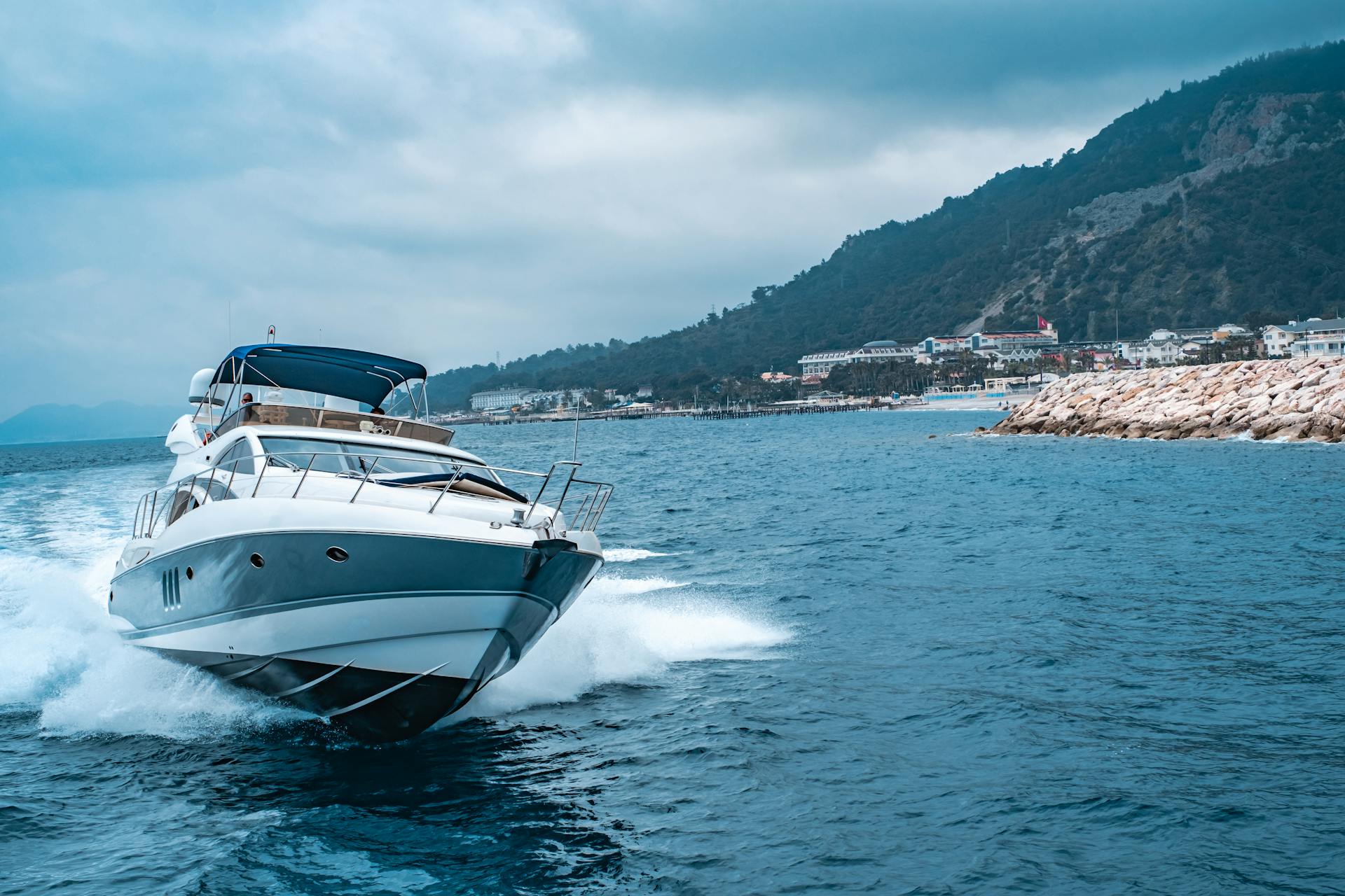 A sleek yacht sails through the turquoise waters of Antalya, Türkiye, showcasing coastal beauty and luxury travel.