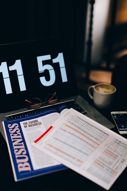 A workspace featuring business analytics documents, laptop, and coffee, symbolizing productivity and analysis.