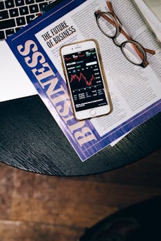 Smartphone displaying stock data on a magazine titled 'The Future of Business'.