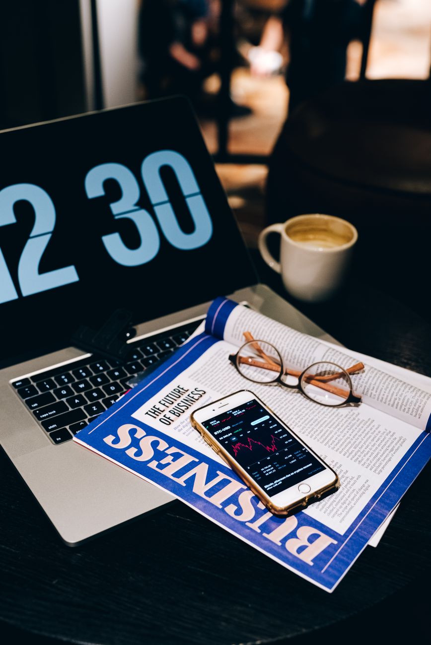 Espace de travail professionnel avec ordinateur portable, smartphone et café pour préparer une newsletter