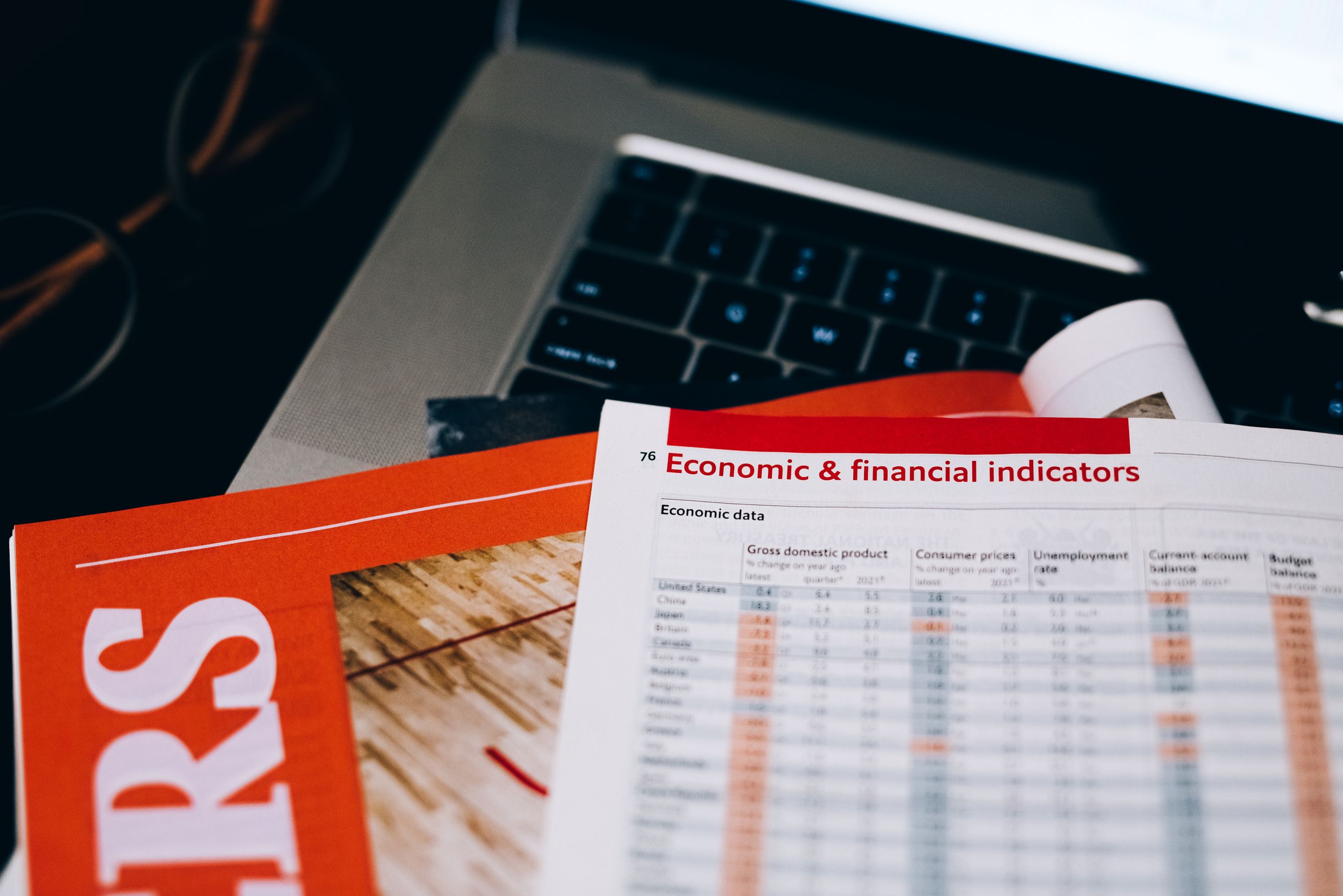 Detailed close-up of economic and financial documents on a laptop keyboard
