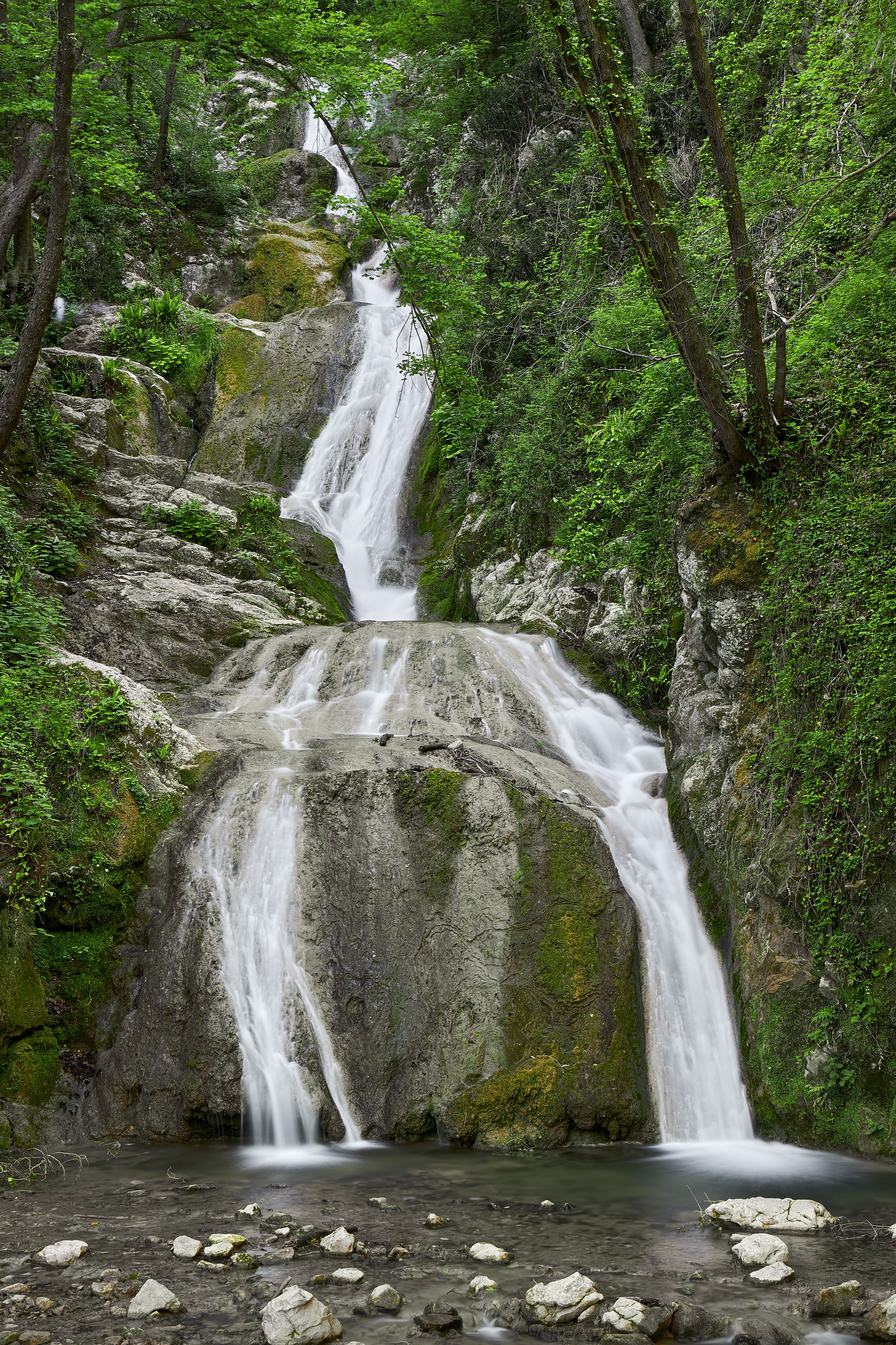 Scenic waterfall surrounded by lush greenery in San Michele, Veneto, Italy.
