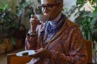 Woman in Brown and White Floral Long Sleeve Shirt Holding White Ceramic Mug