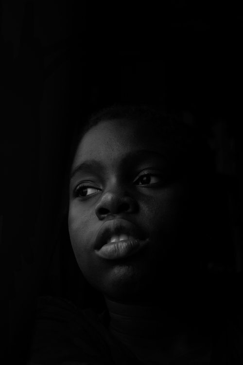 Free Emotive black and white portrait of a child gazing into the distance. Stock Photo