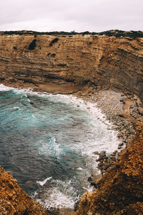 Brown Rock Formation Beside Body of Water