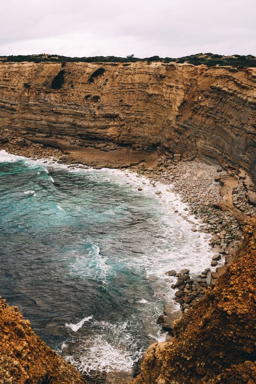 Free Dramatic cliffs and ocean waves in Faro District, showcasing Portugal's rugged coastline. Stock Photo