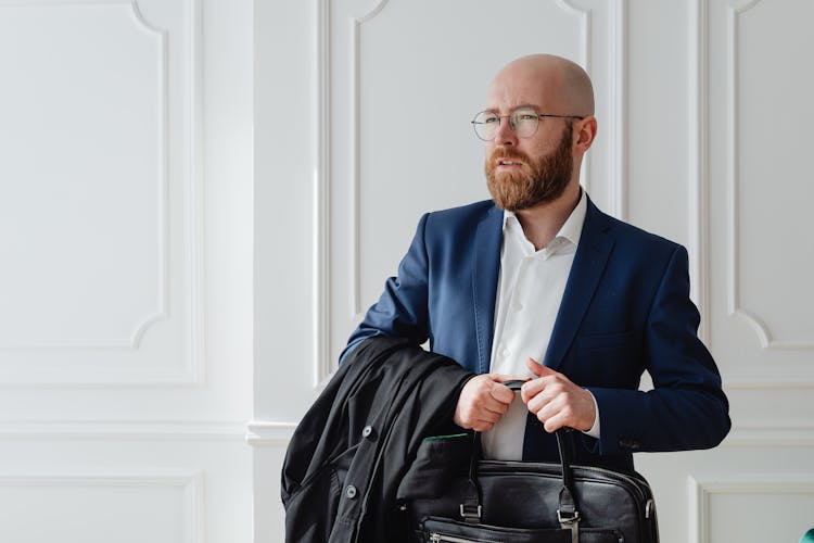 A Bald Man Carrying Black Bag 