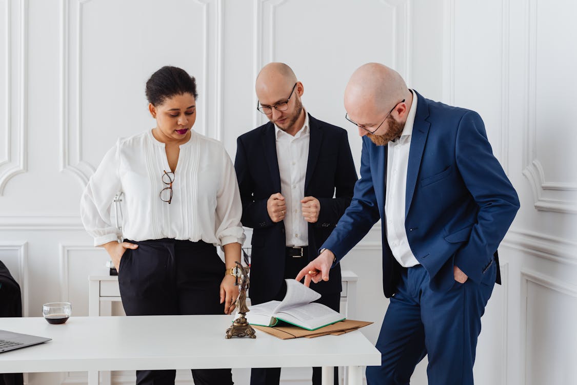 Free A diverse team of professionals analyzing documents in a modern office setting. Stock Photo Free A diverse team of professionals analyzing documents in a modern office setting. Stock Photo