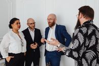 Man in Blue Suit Jacket Standing Beside Woman in Black and White Stripe Long Sleeve Shirt