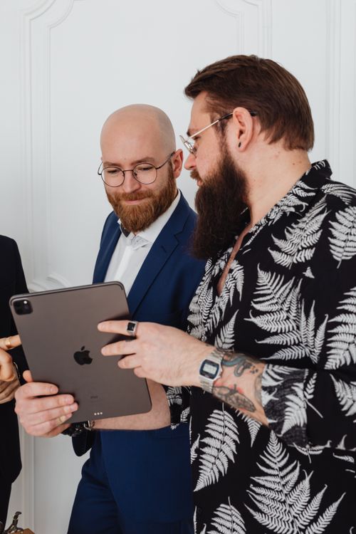 Free Two businessmen in discussion, holding a tablet during a conference indoors. Stock Photo
