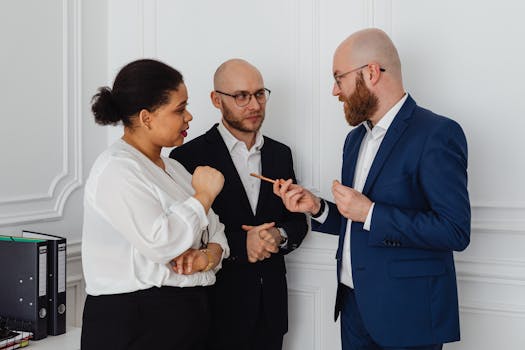 Three professionals engaged in a business discussion in an office setting.