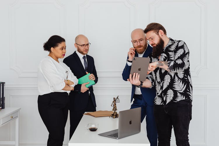 A Man In Black Printed Polo Discussing Business With Business People