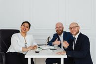 A diverse team of professionals engaged in a collaborative meeting in a modern office setting.
