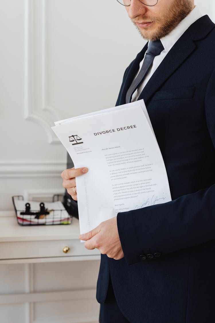 A Man In Black Suit Holding A Divorce Document