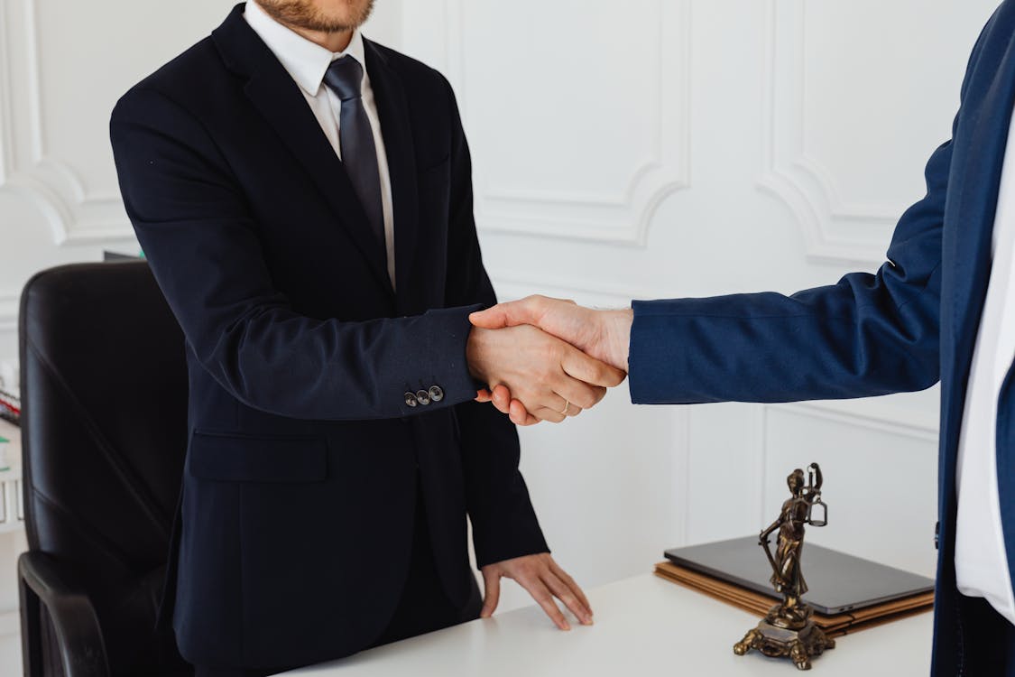Cropped photo of a lawyer and client shaking hands