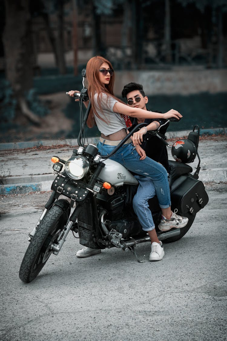 A Young Couple Posing Together On A Motorcycle