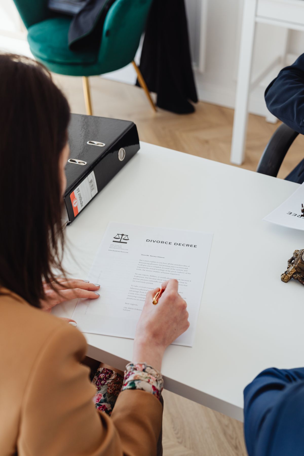 Person signing a family law agreement at a desk