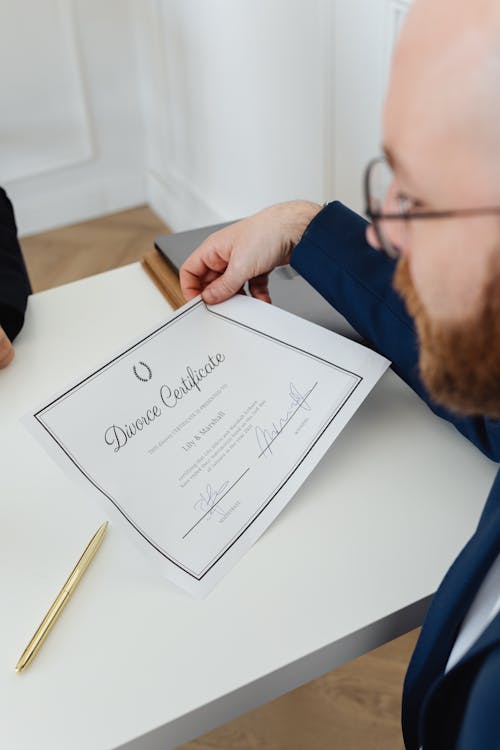 Free Man Looking at a Divorce Certificate Stock Photo