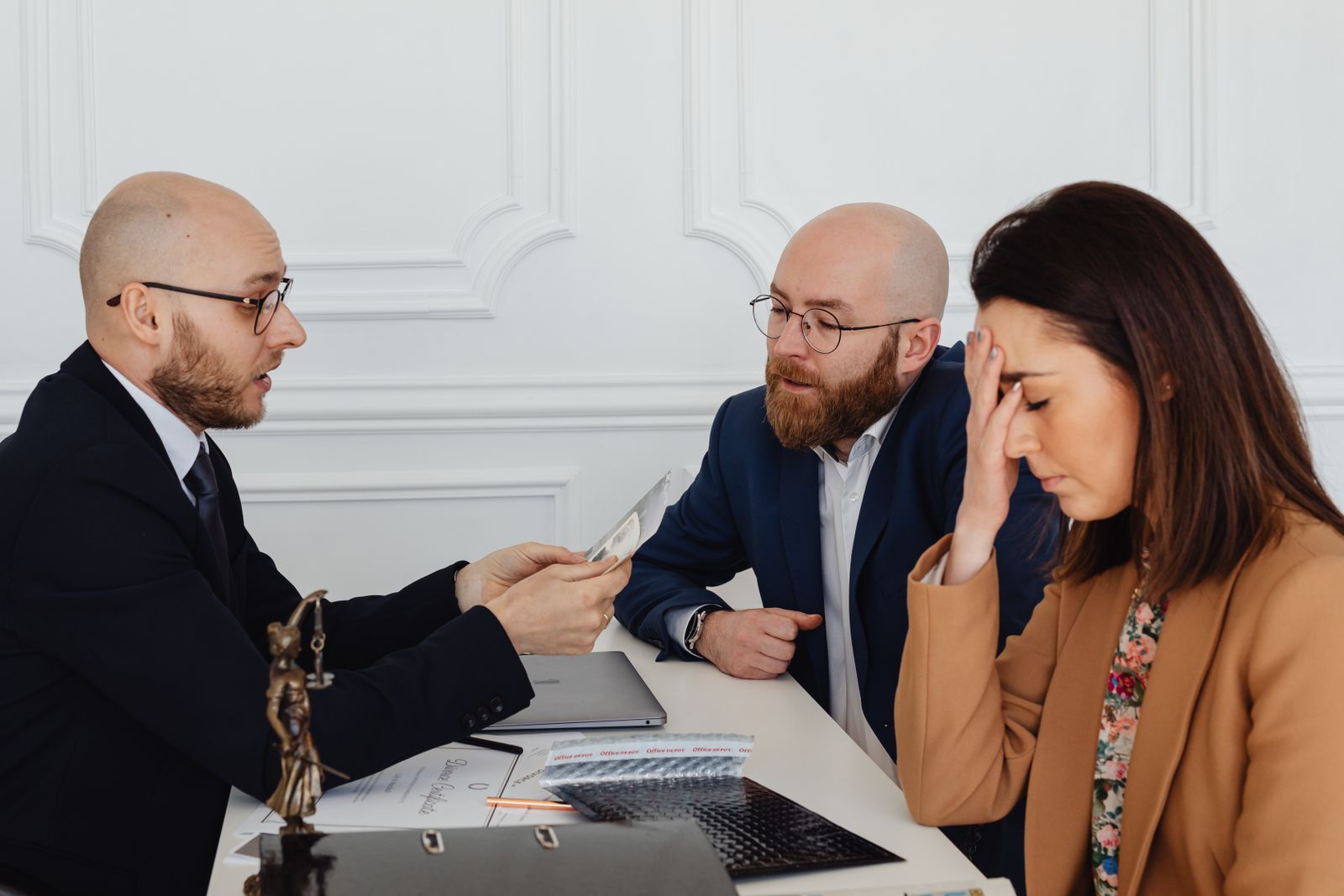 A distressed woman discusses a divorce settlement with an attorney (illustrative stock photography)