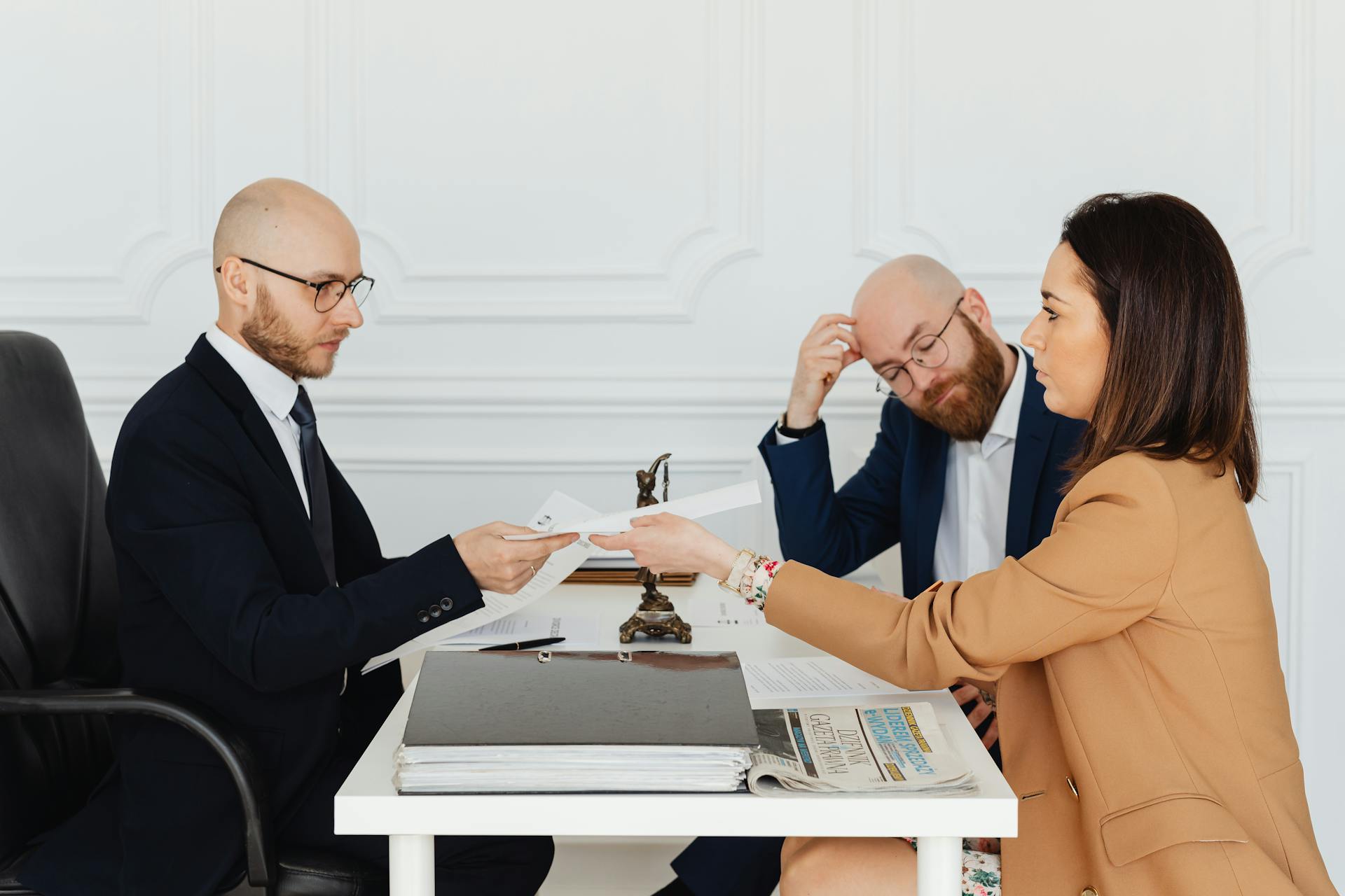 Professional meeting with lawyer and clients discussing documents in a modern office.