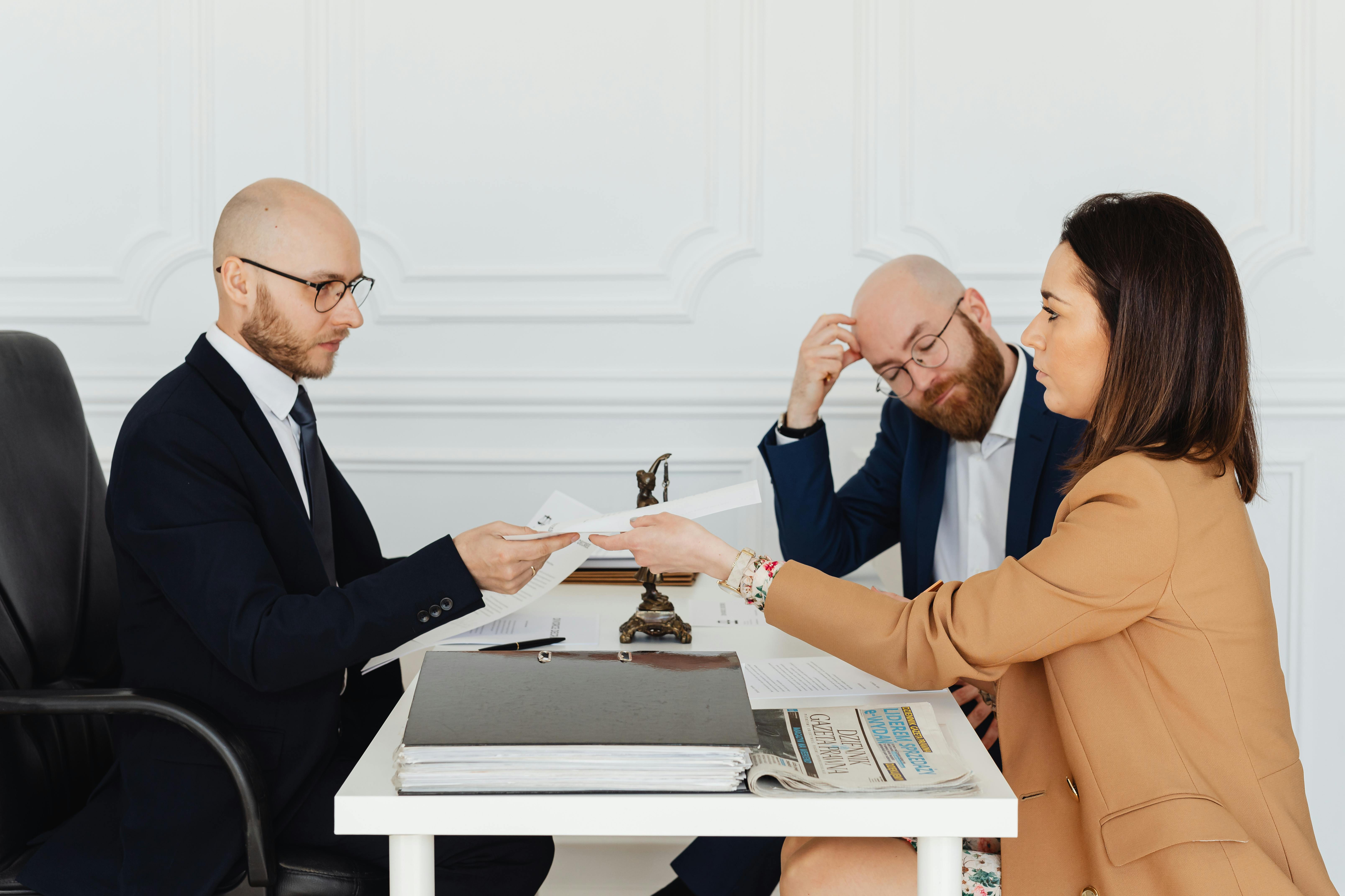 Free Professional meeting with lawyer and clients discussing documents in a modern office. Stock Photo