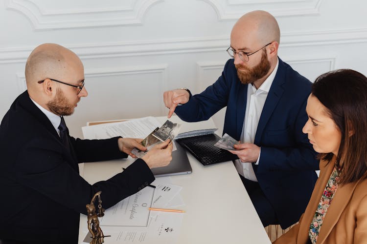 Bearded Man Pointing His Finger On The Photos 