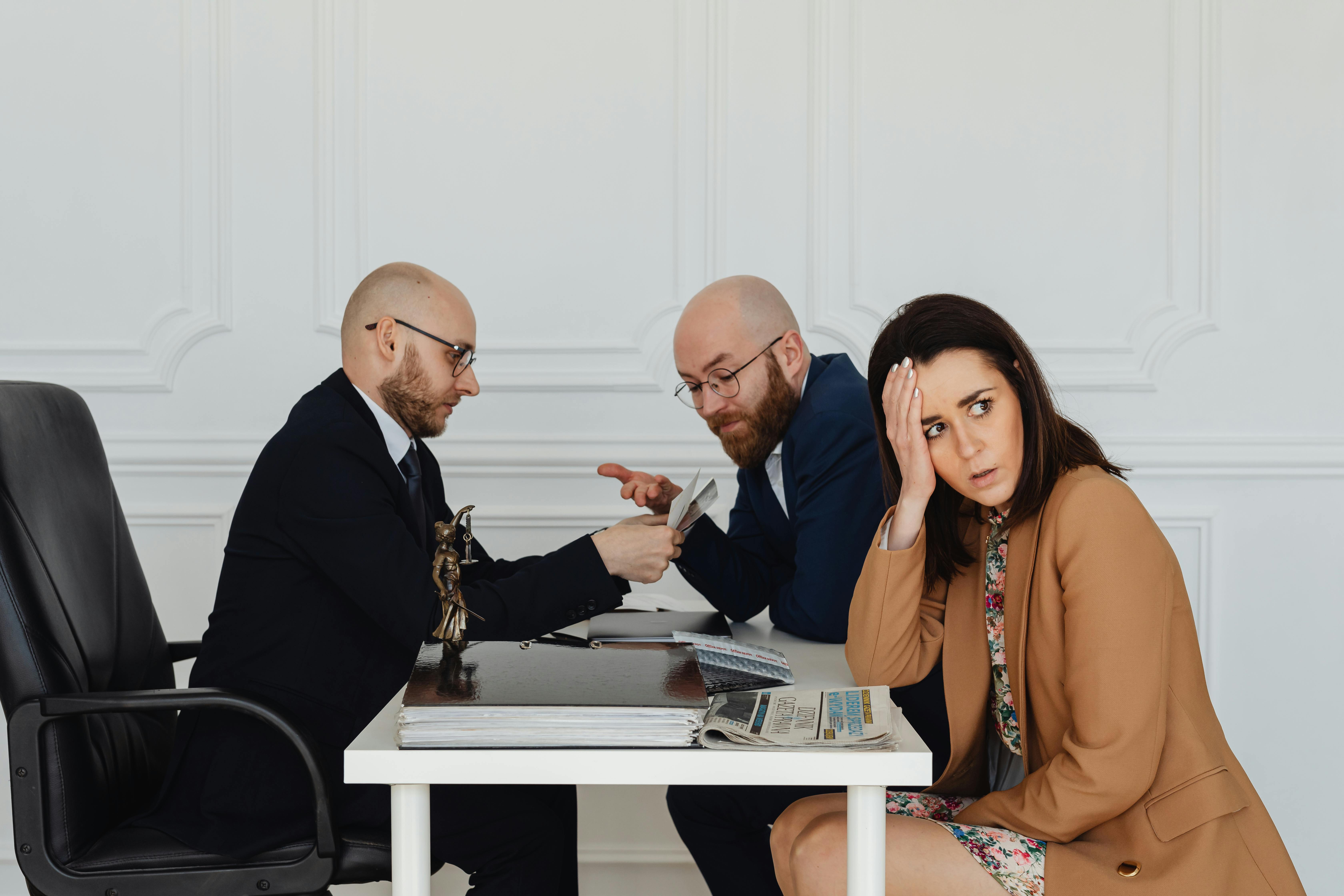 a woman sitting besides lawyers in a law office