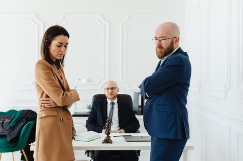 Free A couple in corporate attire seeks mediation during a business disagreement in an office setting. Stock Photo