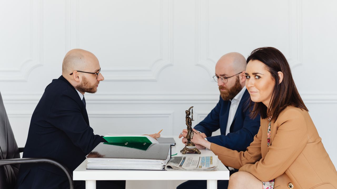 A lawyer consulting a couple in an elegant office setting, focusing on legal matters.