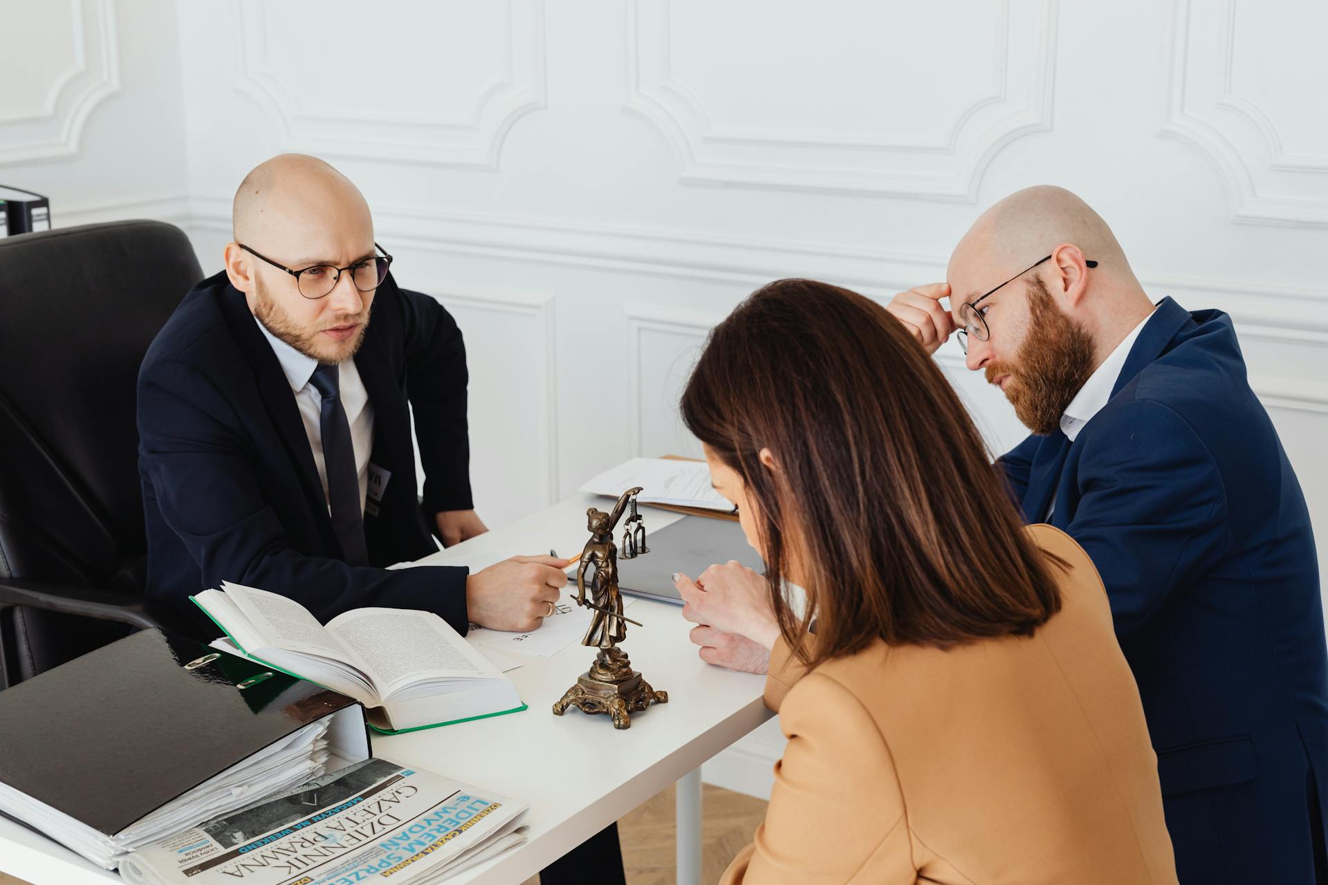 Lawyer consulting clients in a modern office setting, serious discussion.