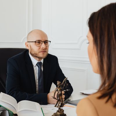 Lawyer consulting with a client next to the Lady Justice statue